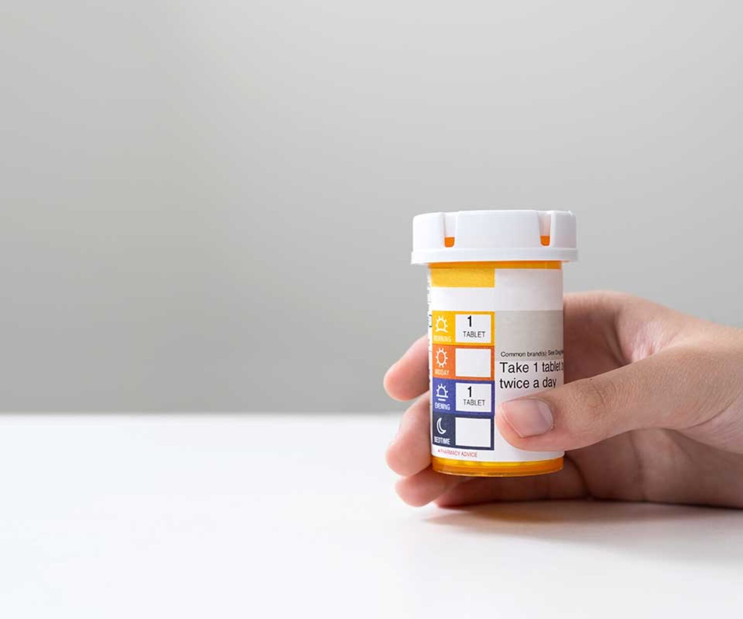 criminal-drug-lawyer-dives-into-prescription-drug-laws-hand-holding-prescription-bottle