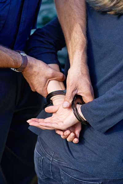 hands-being-crossed-and-cuffed-by-stronger-male-hands-as-a-police-arrest