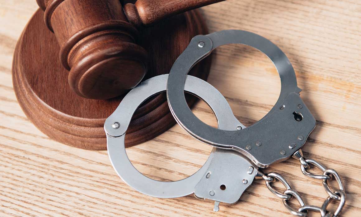 handcuffs-and-gavel-on-light-tabletop-in-a-criminal-law-office-that-takes-cases