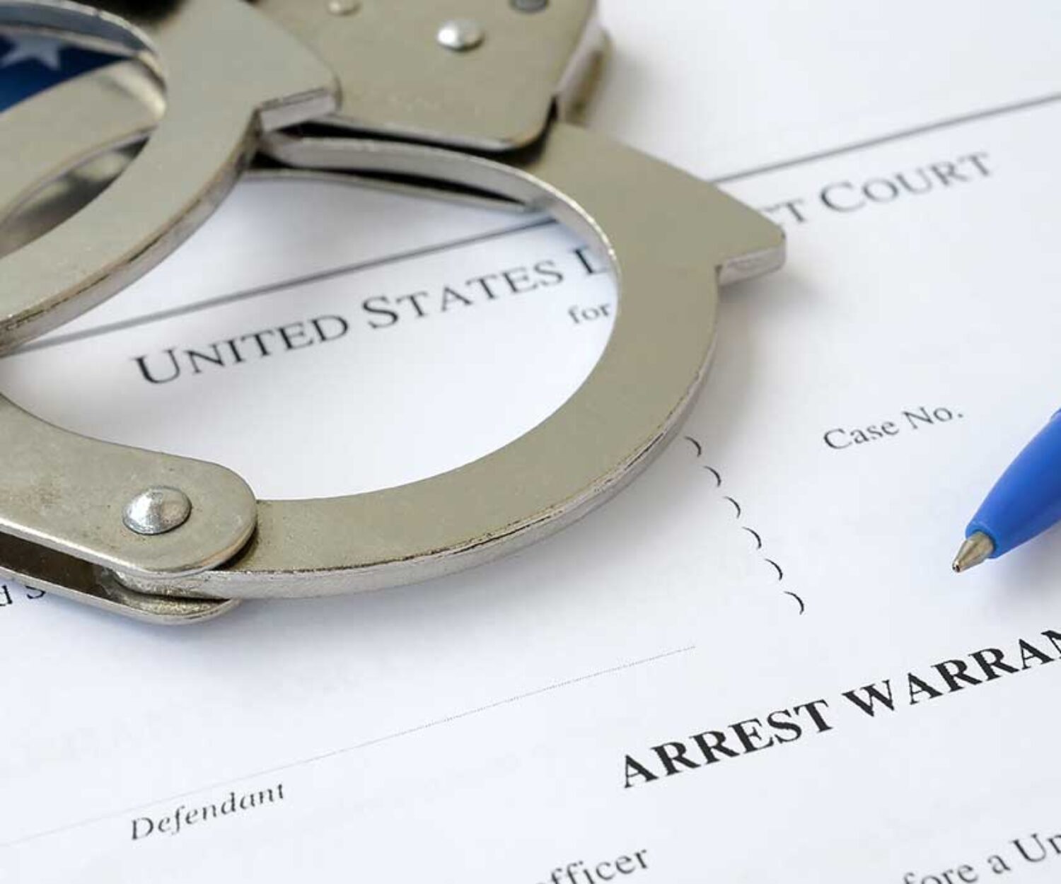 handcuffs-and-pen-laying-on-arrest-warrant-paperwork-for-the-united-states-of-america