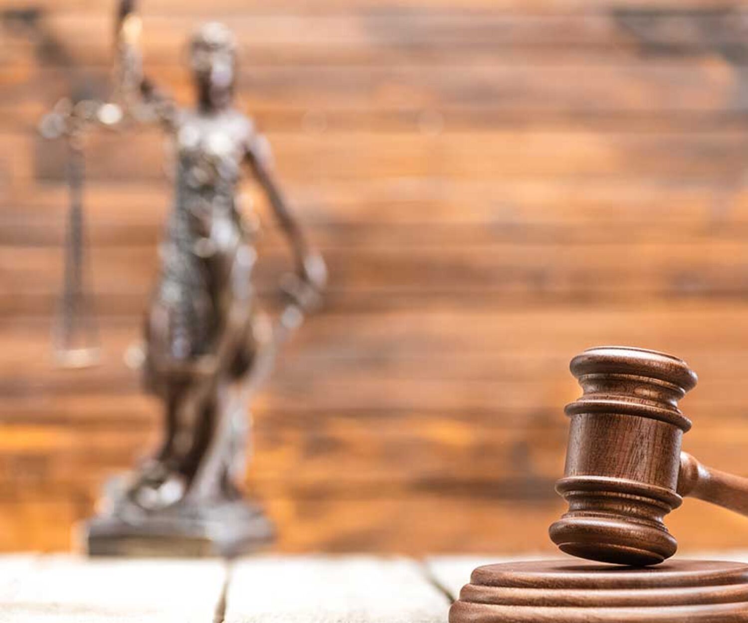 gavel-on-desk-with-law-statue-in-background-for-hero-image-on-blog-post-about-expungement-and-sealing-records-in-florida