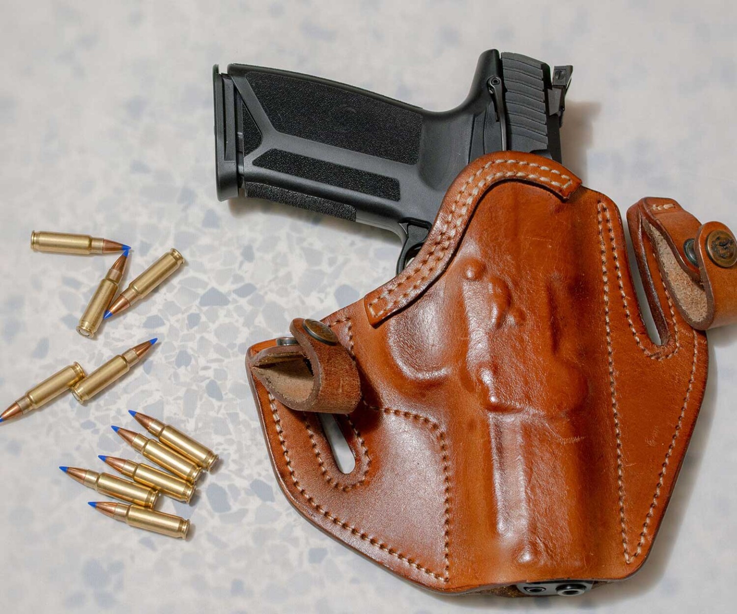 pistol-in-holster-with-bullets-next-to-it-on-tabletop-representing-florida-felony-attorney-that-handles-firearm-cases