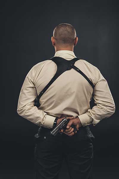 guy-holding-gun-behind-his-back-representing-florida-felony-attorney-and-concealed-carry-laws