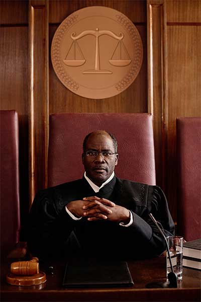 serious-african-american-judge-sitting-in-court-room-staring-directly-into-camera-representing-jacksonville-best-criminal-defense-attorneys