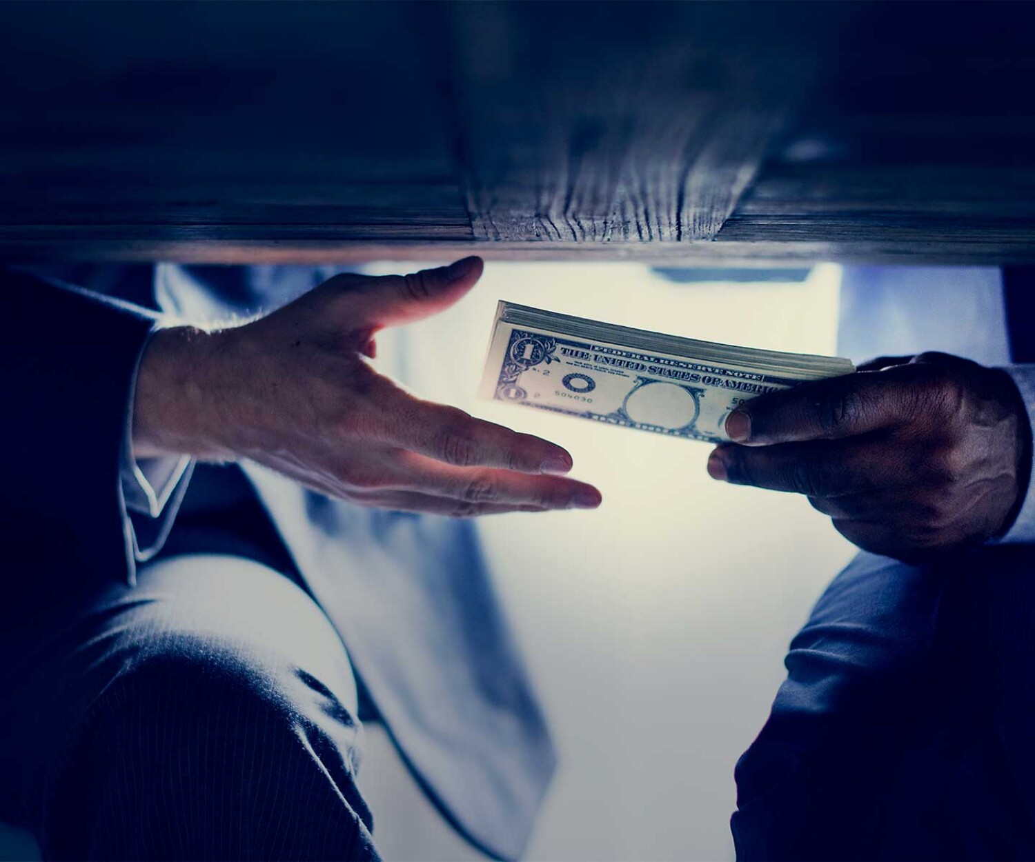 two-men-exchanging-money-under-the-table-showing-criminal-money-case-which-dale-carson-law-felony-lawyer-can-help-with